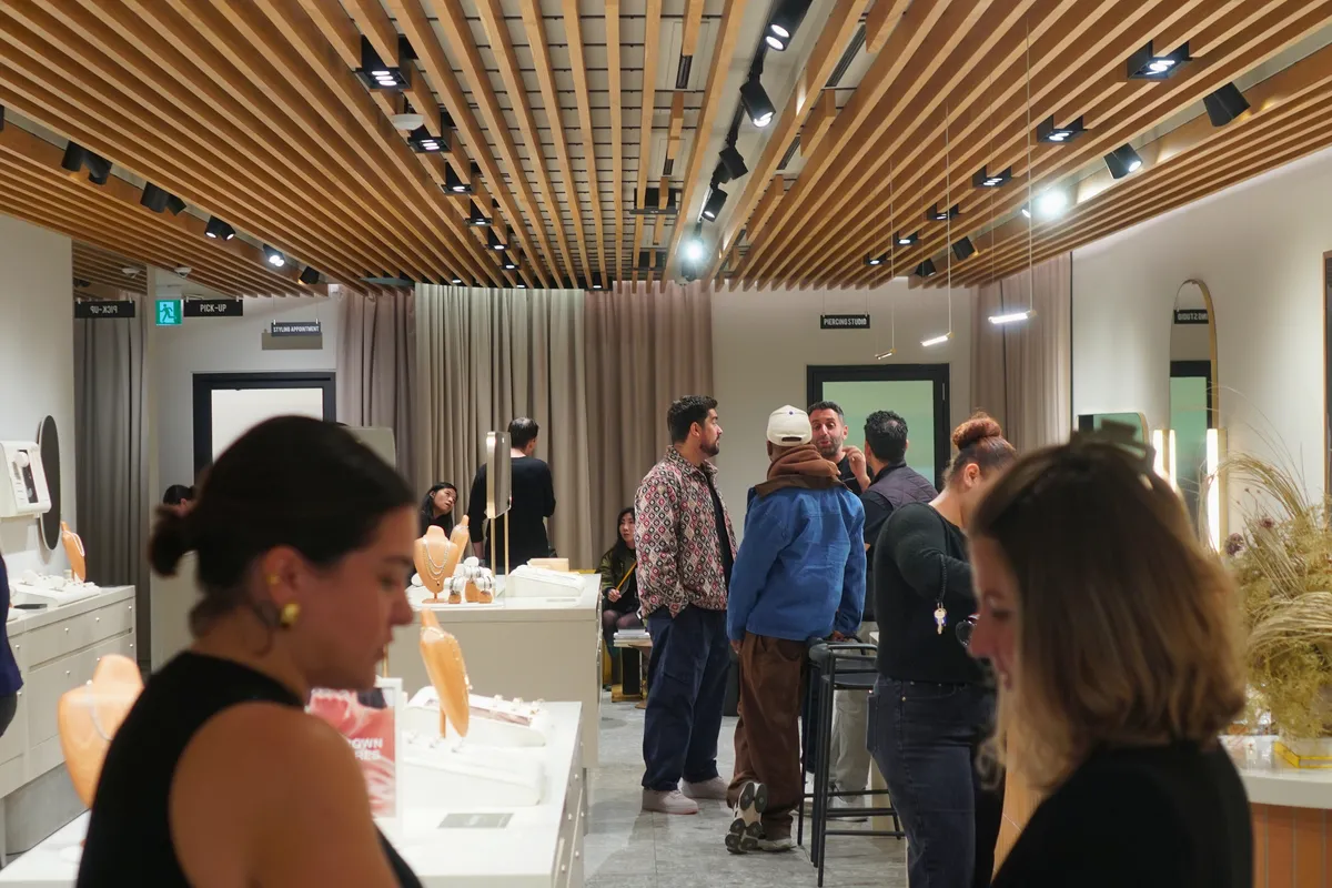 Guests mingling under the slatted wooden ceiling at Mejuri Ossington during Shop & Sip